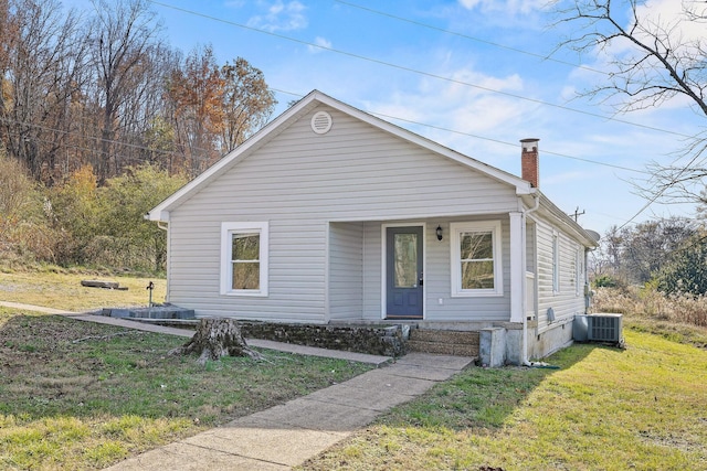 bungalow-style home with a front yard and central air condition unit