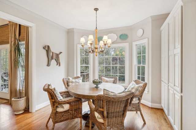 dining room with light hardwood / wood-style floors, crown molding, and a notable chandelier