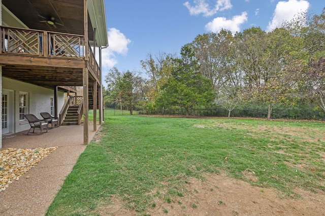 view of yard featuring ceiling fan, a deck, and a patio