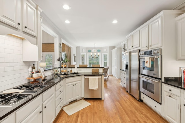 kitchen featuring white cabinetry, appliances with stainless steel finishes, and kitchen peninsula