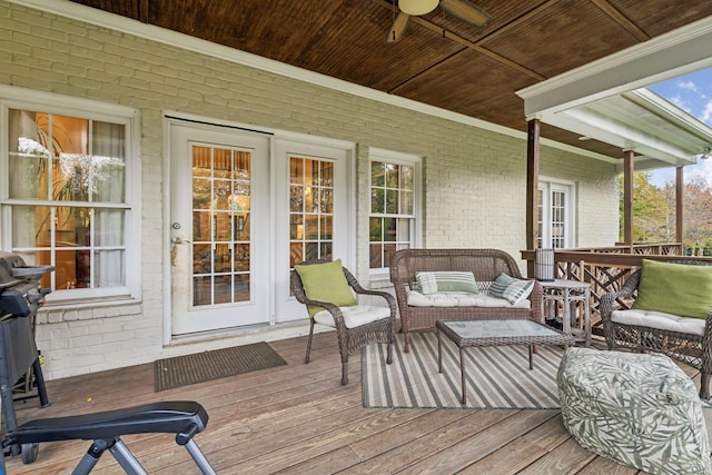 wooden deck with ceiling fan and outdoor lounge area