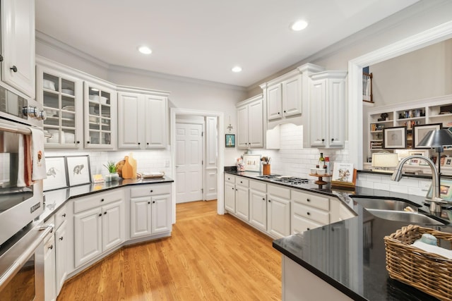 kitchen featuring sink, backsplash, and white cabinets