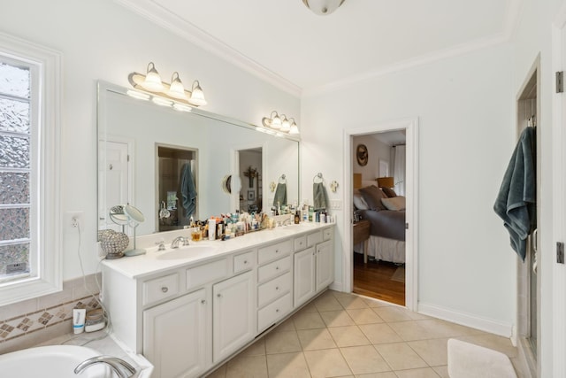 bathroom with a healthy amount of sunlight, tile patterned flooring, vanity, and ornamental molding