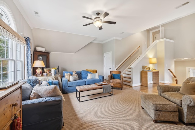 living room featuring ceiling fan, light wood-type flooring, and crown molding