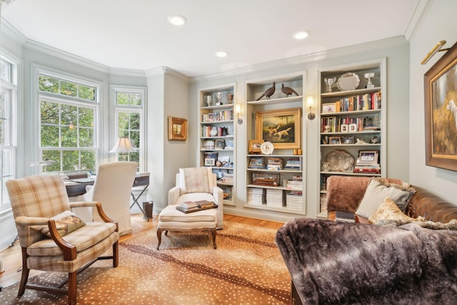 sitting room with hardwood / wood-style flooring, built in shelves, and ornamental molding