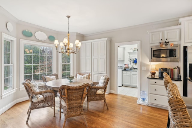 dining area featuring light wood-type flooring, plenty of natural light, ornamental molding, and a notable chandelier