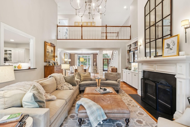 living room with dark wood-type flooring, crown molding, a towering ceiling, and an inviting chandelier