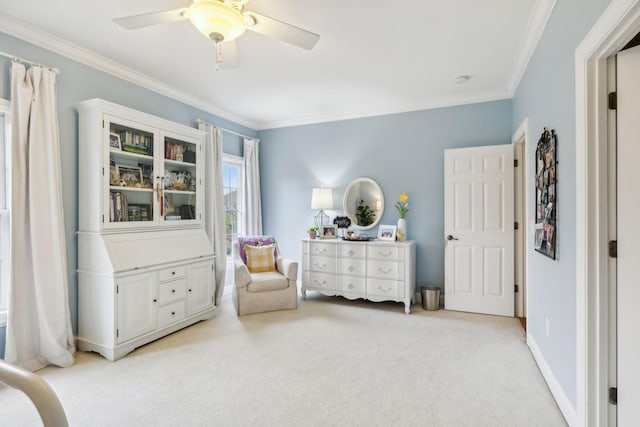 living area featuring ceiling fan, ornamental molding, and light carpet