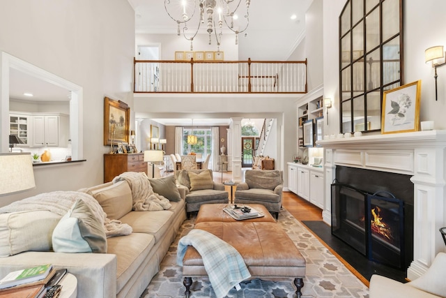 living room featuring dark hardwood / wood-style flooring, crown molding, a chandelier, and a high ceiling