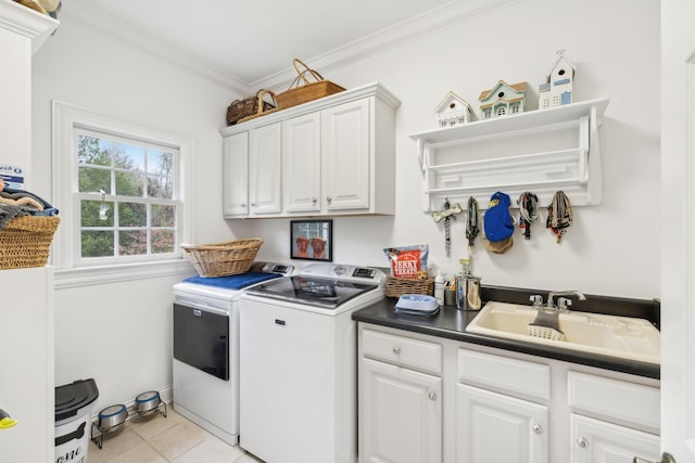 washroom featuring separate washer and dryer, cabinets, sink, light tile patterned floors, and crown molding