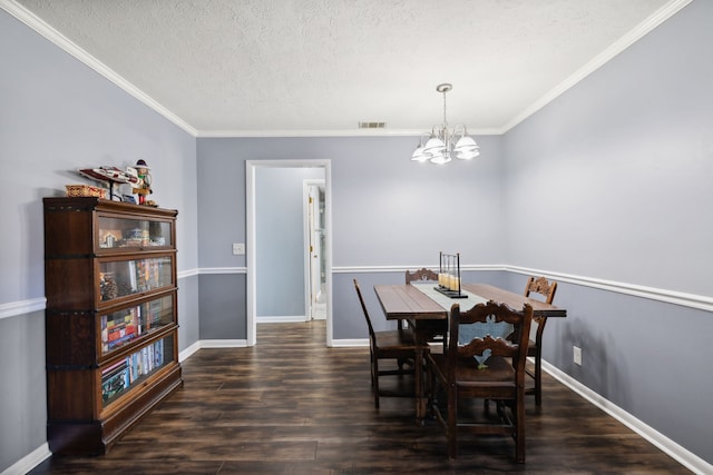 dining space featuring dark hardwood / wood-style flooring, a chandelier, a textured ceiling, and ornamental molding