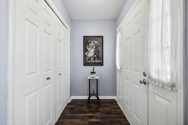 doorway to outside featuring dark wood-type flooring and a textured ceiling