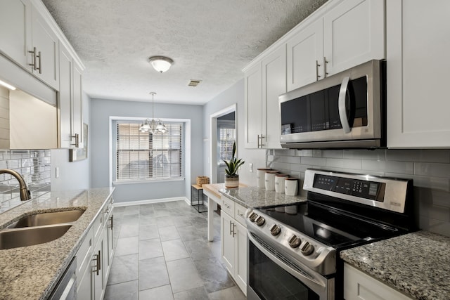 kitchen featuring white cabinets, stainless steel appliances, tasteful backsplash, and sink