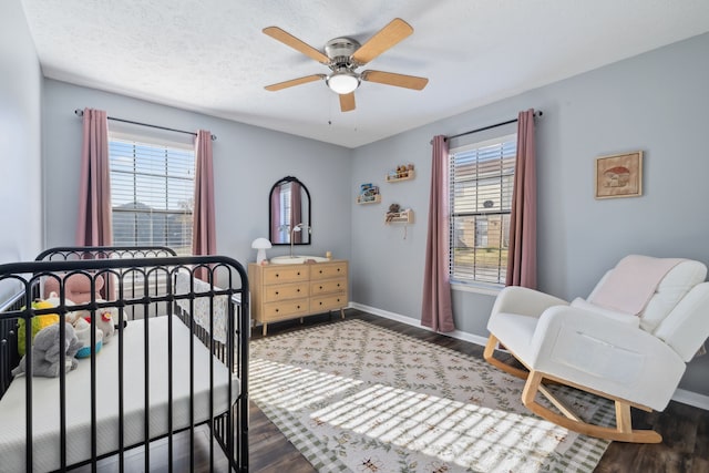 bedroom with ceiling fan, dark wood-type flooring, and a textured ceiling