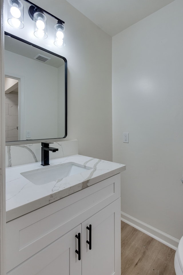 bathroom featuring hardwood / wood-style floors, vanity, and toilet