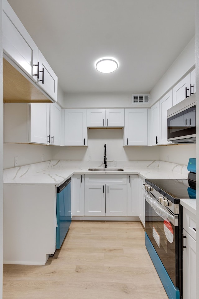 kitchen featuring light wood-type flooring, white cabinetry, sink, and appliances with stainless steel finishes