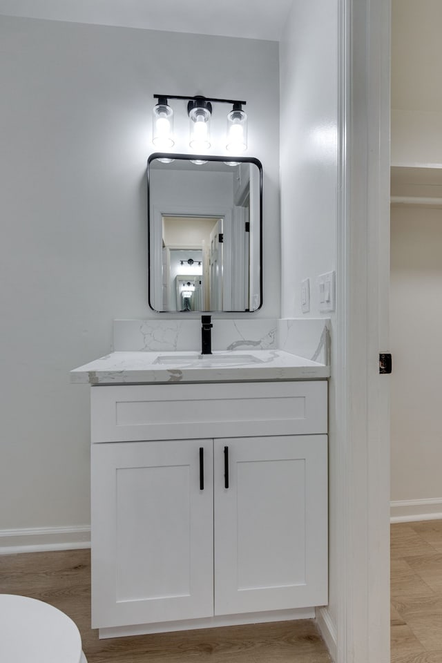 bathroom with vanity, hardwood / wood-style flooring, and toilet