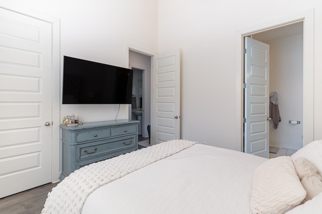 bedroom with hardwood / wood-style floors and connected bathroom