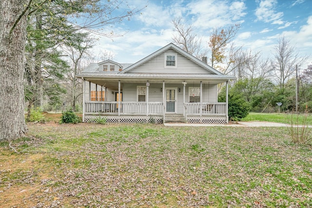 farmhouse-style home featuring a porch and a front yard