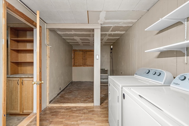 clothes washing area with light wood-type flooring and washer and clothes dryer