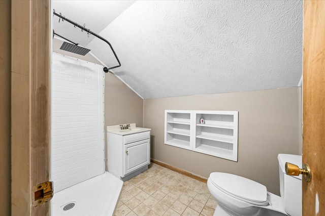 bathroom with vanity, a shower, lofted ceiling, and a textured ceiling