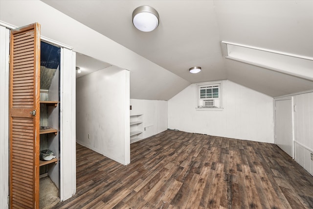 additional living space featuring lofted ceiling, cooling unit, and dark wood-type flooring