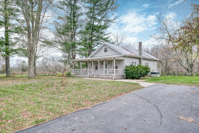 2269 Bowman Loop, Crossville, TN 38571 - view of front facade with a porch, a front yard, and metal roof