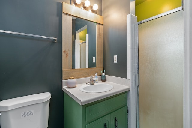 bathroom with vanity, a shower with shower door, and toilet