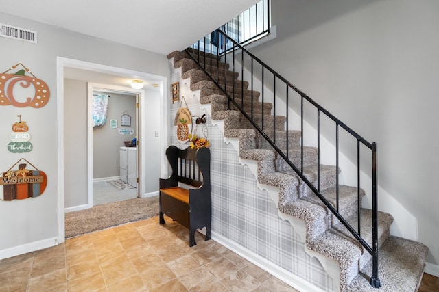 stairs featuring washing machine and dryer