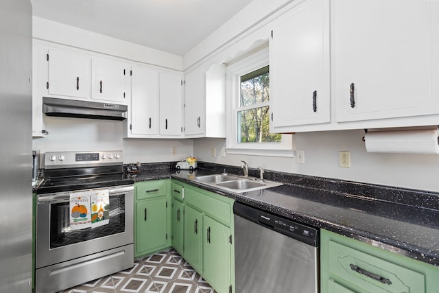 kitchen with white cabinets, stainless steel appliances, dark stone countertops, and sink