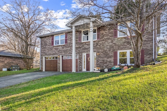 view of front of house featuring cooling unit, a garage, and a front lawn