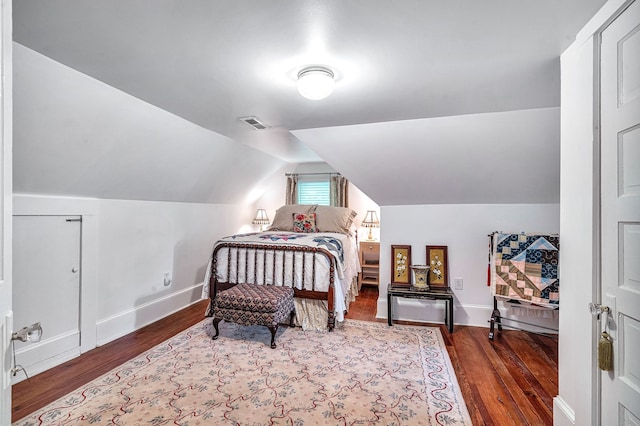 bedroom with dark wood-type flooring and vaulted ceiling