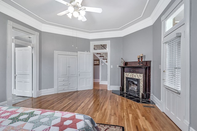 bedroom with ceiling fan, wood-type flooring, and ornamental molding