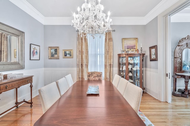 dining area with light hardwood / wood-style floors, a notable chandelier, and ornamental molding