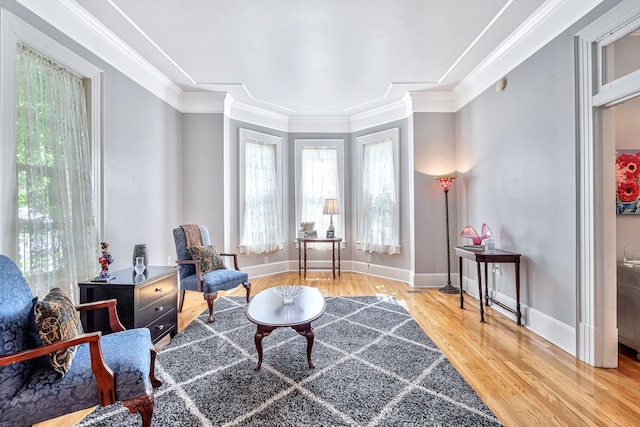 sitting room featuring ornamental molding and hardwood / wood-style flooring