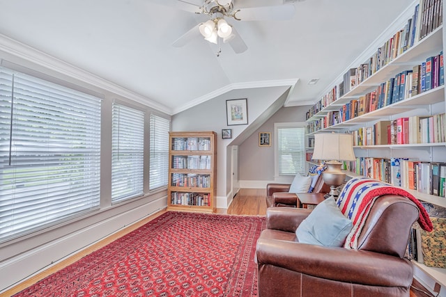 sitting room with wood-type flooring, ornamental molding, lofted ceiling, and ceiling fan