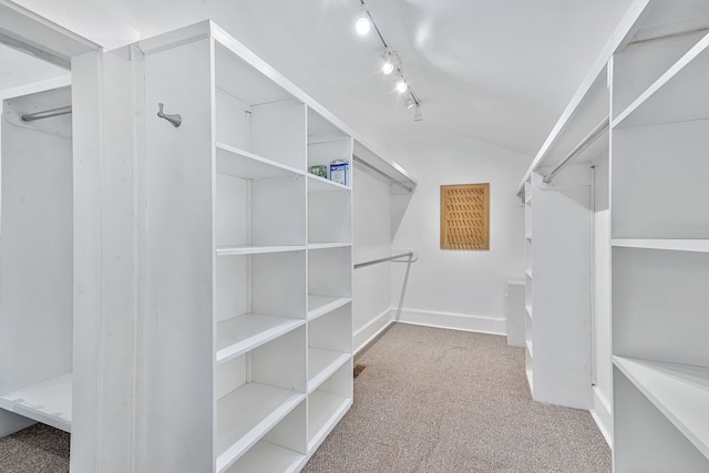 walk in closet featuring light carpet and vaulted ceiling