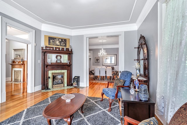 living room with a chandelier, wood-type flooring, and ornamental molding