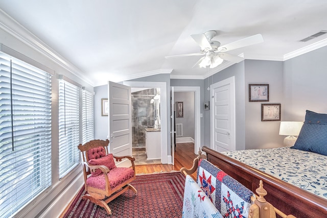 bedroom featuring ensuite bath, ceiling fan, wood-type flooring, and multiple windows