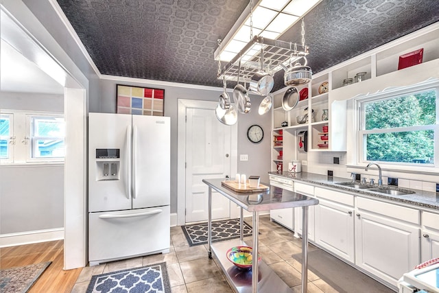 kitchen featuring sink, light hardwood / wood-style floors, white appliances, white cabinets, and ornamental molding