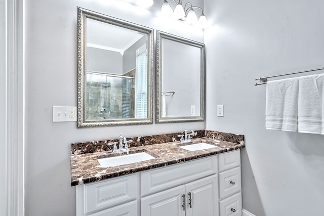 bathroom featuring vanity, a shower with shower door, and ornamental molding