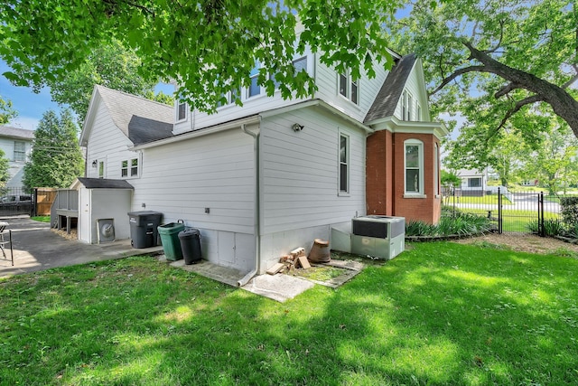 rear view of property featuring cooling unit and a yard