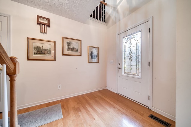 entryway featuring light hardwood / wood-style floors and a textured ceiling