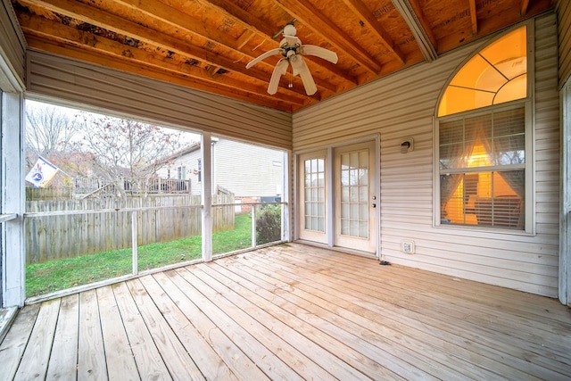 unfurnished sunroom with ceiling fan, beamed ceiling, and wood ceiling