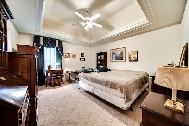 bedroom with carpet flooring, ceiling fan, and a tray ceiling