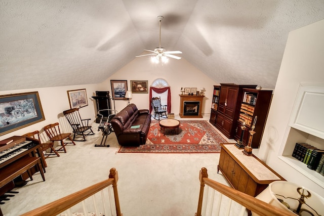 living room featuring ceiling fan, light colored carpet, lofted ceiling, and a textured ceiling