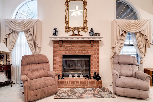 sitting room with a brick fireplace and plenty of natural light