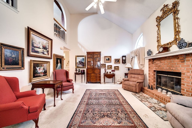 carpeted living room with a brick fireplace, high vaulted ceiling, and ceiling fan