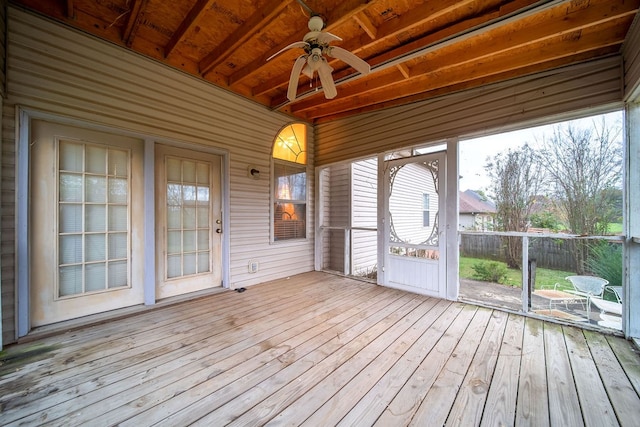 unfurnished sunroom with beamed ceiling, ceiling fan, and wooden ceiling