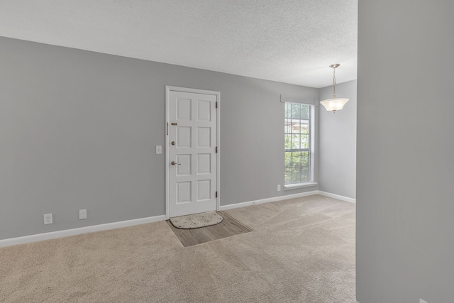 carpeted empty room with a textured ceiling